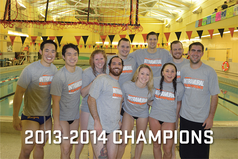 A group of swimmers stand in front of a pool in champions t-shirts.
