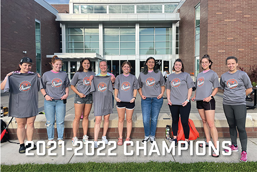 Photo that says 2021-2022 Champions. Photo shows women's softball team wearing their champions t-shirts in front of Dixon Recreational Center.