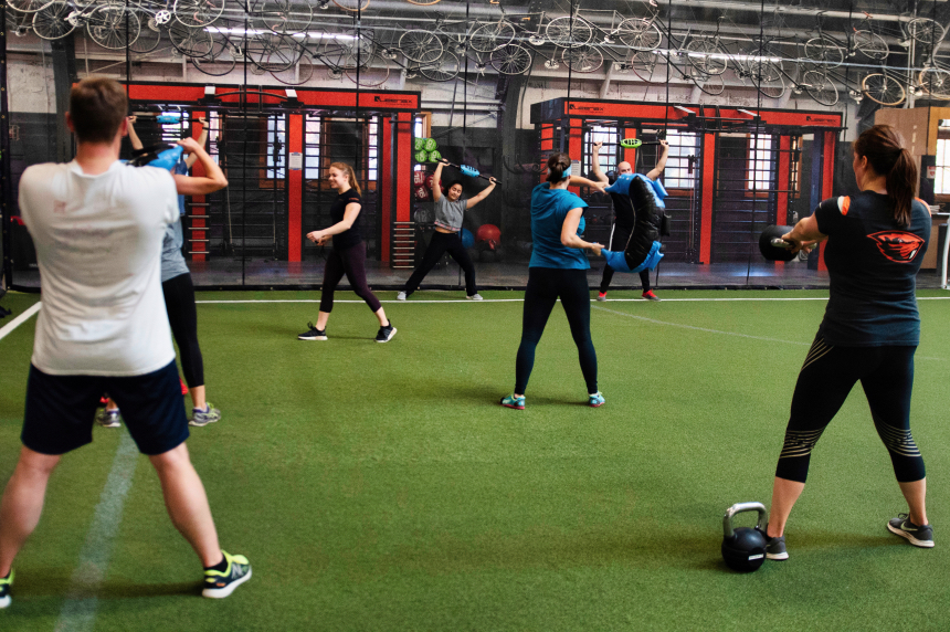 Dam Fit Class in session, students using kettle bells and bulgarian bags