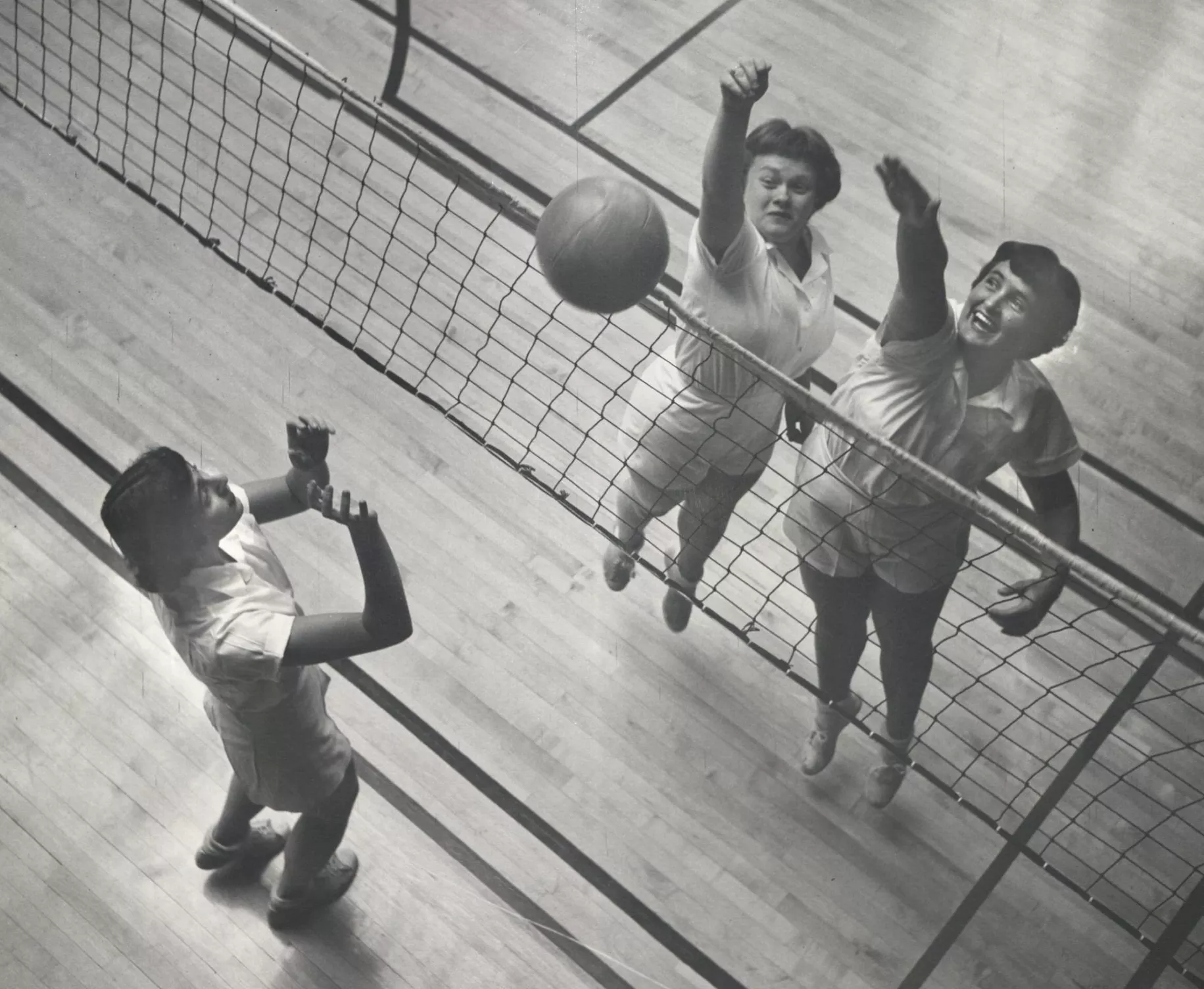 Historic black and white image of volleyball players. 