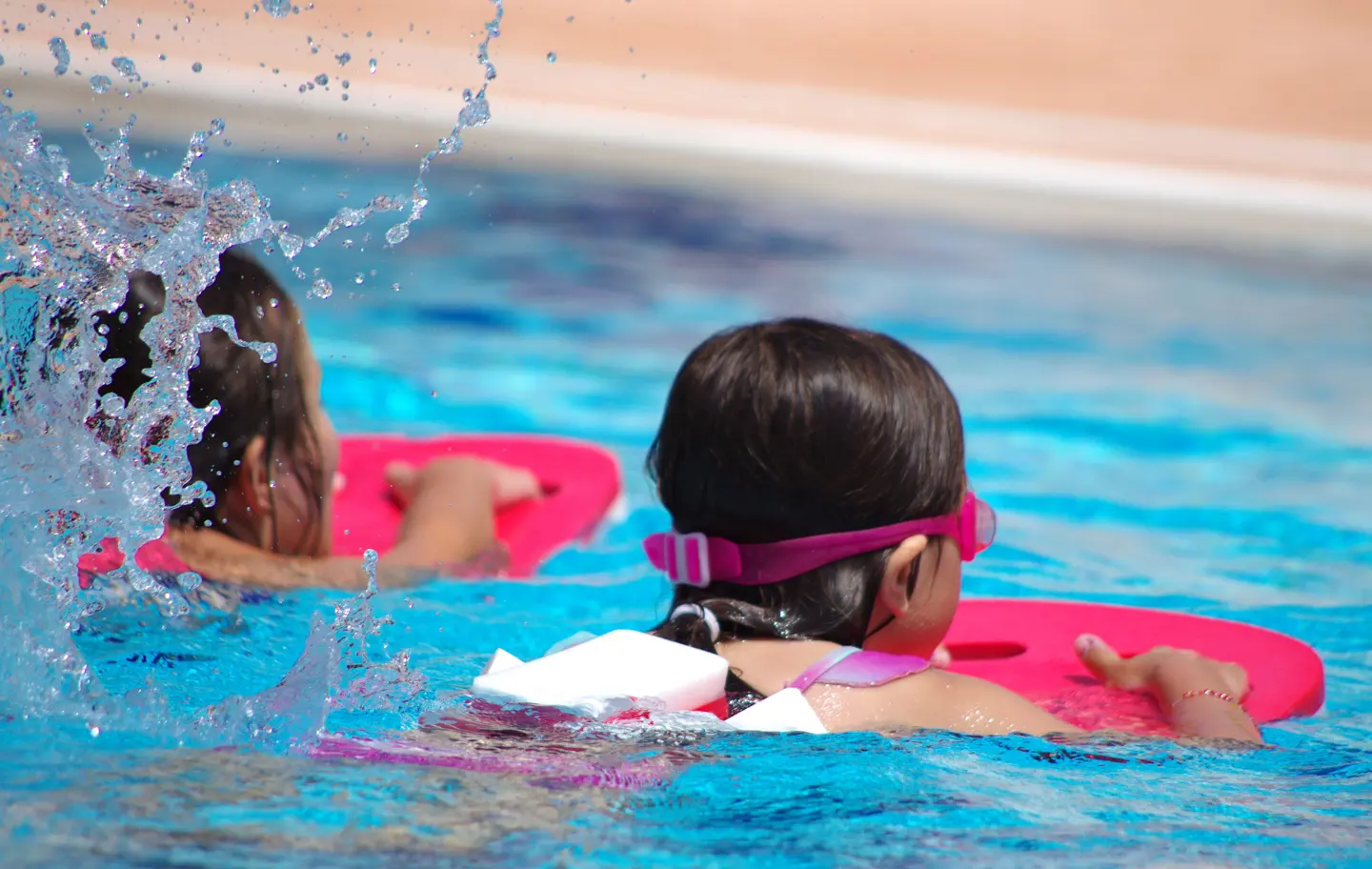 Youth swim lesson participants practice kicking